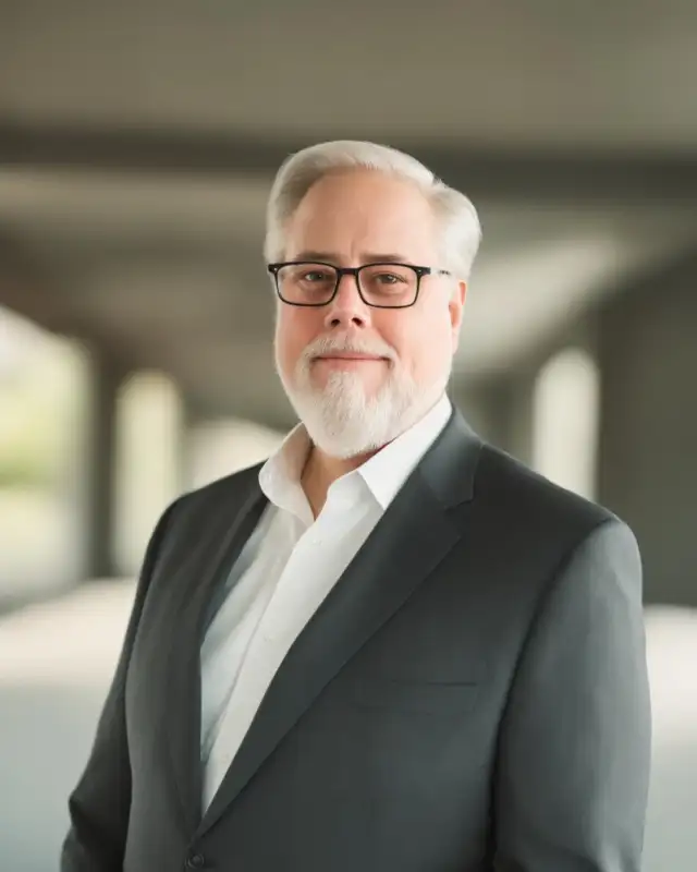 Douglas Karr in a charcoal suit and glasses.